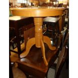 A 29 1/2" diameter modern blonde wood pedestal table, set on turned pillar and quadruple cabriole