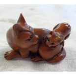 A carved and stained wood netsuke in the form of a cat and kitten - signed