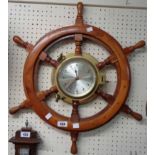 A modern brass cased bulkhead timepiece with quartz movement, set in a polished ship's wheel pattern