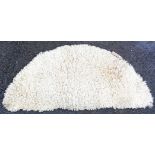 A semi circular natural sheepskin rug - 4' 2" X 24"