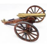 A brass and wood model field cannon and accessories