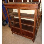 A 3' 1" old bituminised oak display cabinet with shelves enclosed by a pair of beaded glazed panel