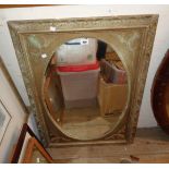 An ornate antique style gilt framed oval wall mirror with applied acanthus fan decoration
