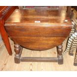 A 19" 1920`s stained oak joint stool style drop-leaf low table with swivel action, set on turned