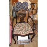 A late Victorian ebonised framed elbow chair with ornate top rail, pierced splat back and