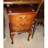 A pair of reproduction mixed wood bedside cabinets, each with a drawer and false drawer fronted