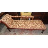 A 6' 4" Edwardian stained oak chaise longue with spindle back rail, floral repeat pattern