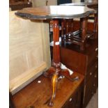 A 22" Victorian walnut pedestal table with shaped top, set on turned and reeded pillar with tripod