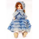 An antique Simon & Halbig porcelain head doll with sewn stuffed body in original blue clothing