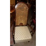 A pair of 1930`s stained wood framed high hoop back elbow chairs with woven cane back panels and