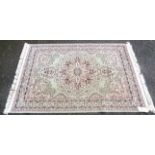 A modern machine made rug with Middle Eastern style floral medallions on pale jade ground, within