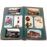 A green Edwardian postcard album containing a collection of mainly early 20th Century postcards