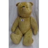 A vintage hump back Teddy bear with jointed limbs and remains of plush finish