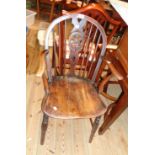 An antique wheel back elbow chair with solid elm seat, set on turned supports - old repair