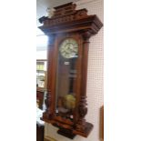 An early 20th Century polished walnut cased Vienna style wall clock with decorative dial, visible