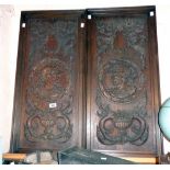 A pair of 19th Century carved and stained oak Romaine head panels, with scroll borders