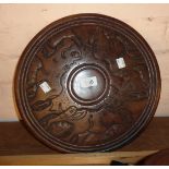 An old African carved hardwood circular plaque with animal decoration both sides