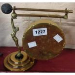 An Art Deco brass table gong with figural support on bakelite collar