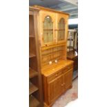A 3' 1" modern Regent Pine two part dresser with illuminated and part glazed top section over a base