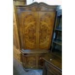 A 34" reproduction figured walnut corner cupboard with two pairs of doors, slide and canted sides,