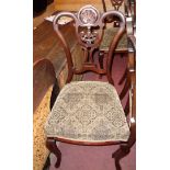 A set of four late Victorian mahogany framed dining chairs with ornate pierced splat backs and