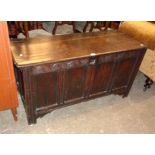 A 4' 6" antique oak four panel linen chest with later base boards, set on bracketed moulded block