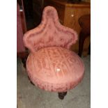 A Victorian upholstered boudoir shaped button back nursing chair with circular seat, set on turned