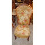 A Victorian walnut part show frame spoon back nursing chair with floral tapestry upholstery, set