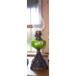 A Victorian table oil lamp with green glass reservoir and cast iron base