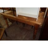 A 5' modern polished pine kitchen table, set on turned legs