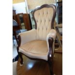 A late 20th Century button back fireside armchair in the Victorian style with part show frame and