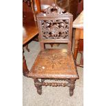 A Victorian carved and polished oak hall chair with decorative pierced acanthus scroll and boss back