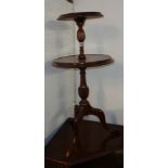 A small reproduction mahogany two tier dumb waiter, set on reeded turned pillar and tripod base