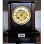 A late Victorian black slate and red marble cased mantel clock with French bronze medal eight day