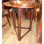 A 26" diameter polished oak table with small drawer to apron, set on triple bobbin turned supports