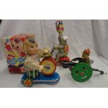 A vintage tin plate toy elephant on a tricycle, a man with a cannon and a later similar