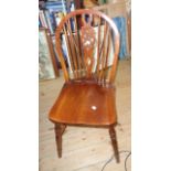 A set of four 20th Century wheel back kitchen chairs set solid elm seats, set on turned supports