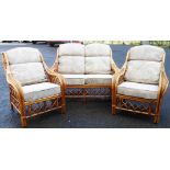 A three piece cane conservatory suite comprising two chairs and a two seater settee, with cushions