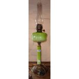 A Victorian table oil lamp with green opaque glass reservoir and stem