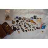 A collection of badges including Royal Marines and RASC cap badges, RAFA, RBL, Butlins, For Home and