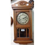 An early 20th Century stained walnut cased wall clock with visible pendulum and eight day gong