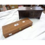 A boxed set of dominoes with cribbage board to top and a coffer style box