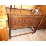 A 3' 5 1/2" early 20th Century carved oak side cabinet with decorative detail to front and