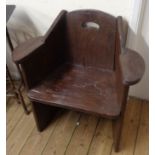 A pair of rustic stained hardwood garden elbow chairs with pierced handle backs, solid seats and