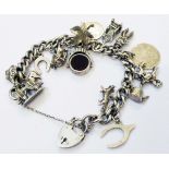 A silver kerb-link charm bracelet with heart shaped padlock and a selection of silver and white