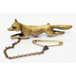 A marked 15c yellow metal fox pattern brooch with pink stone eyes and safety chain