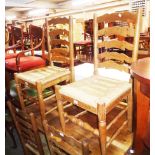 A set of six polished oak framed ladder back dining chairs with woven rush seats, set on turned