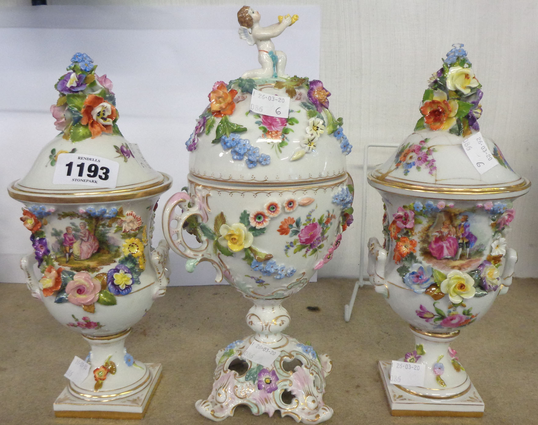 A Dresden floral and cherub decorated cup and cover - sold with two similar