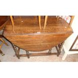 A 3' 5" 1920's stained oak gateleg dining table, set on barley twist supports