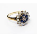 A hallmarked 375 gold ring encrusted with small sapphires and diamonds